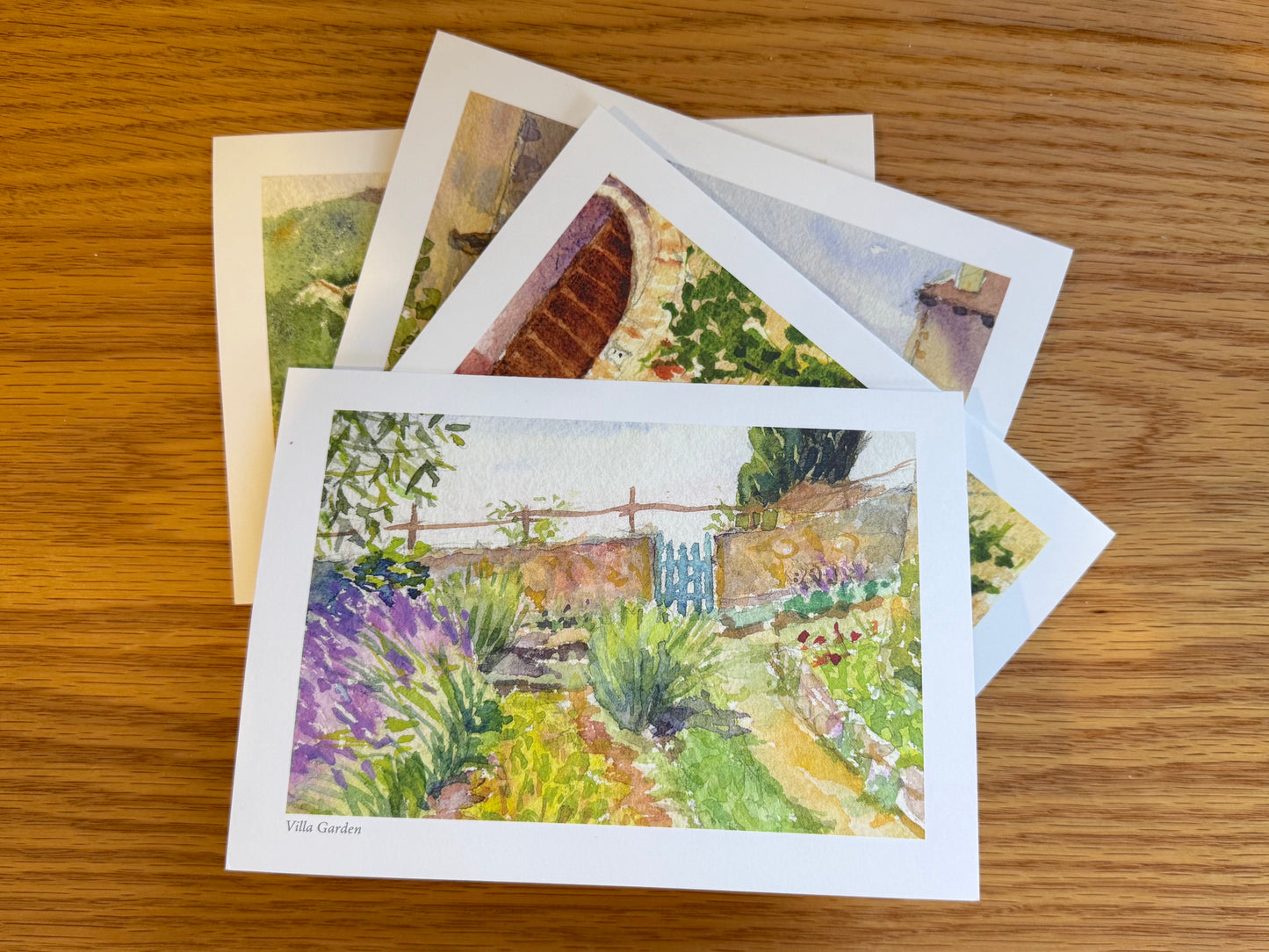 Set of four notecards lying flat on a wooden surface