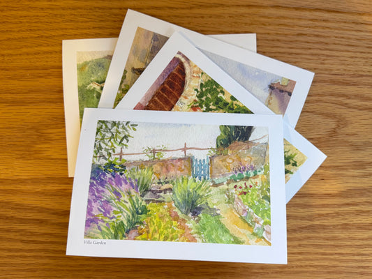 Set of four notecards lying flat on a wooden surface