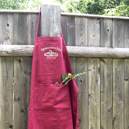 Red apron hanging on fence post